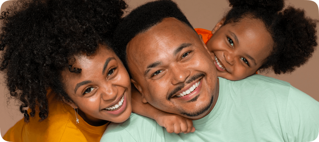 An image of a man and his two daughters smiling